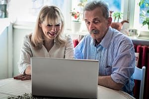 man and woman looking at computer