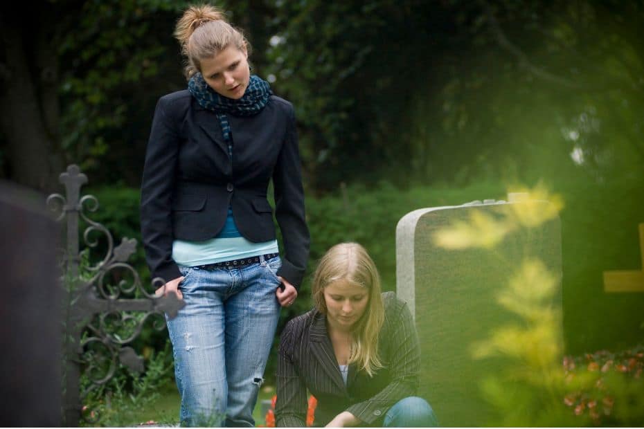 Two women tending to a grave