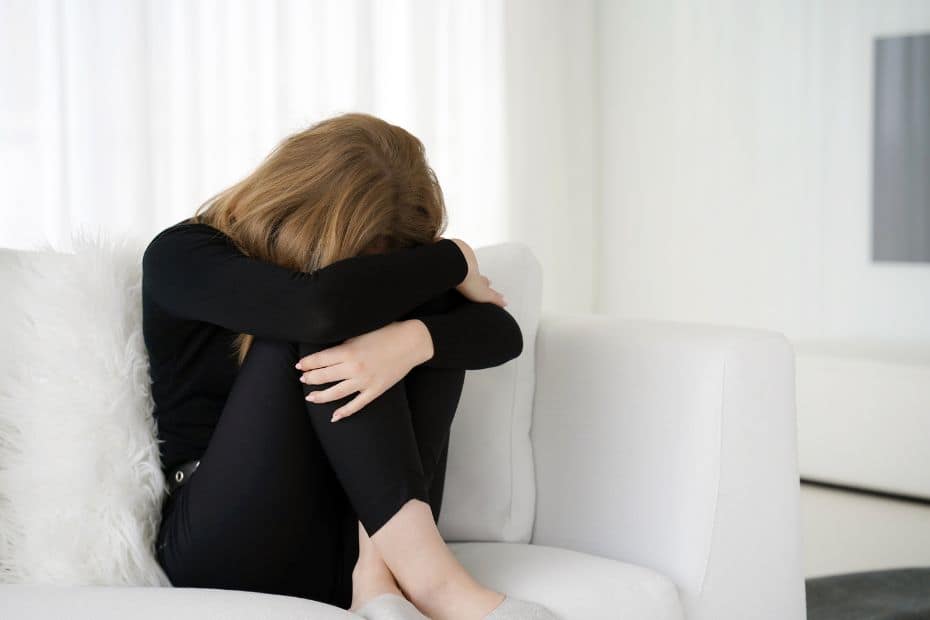 Lady sitting on sofa with head in hands